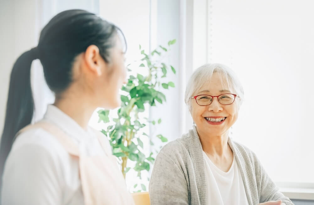 介護士と利用者さんが目線を合わせて微笑んでいる様子